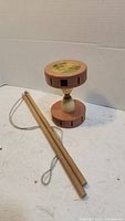 Chinese yo-yo with wooden sticks on white surface, showing full item and accessory