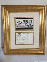 Framed Esso post card consisting of front and back of card mounted behind glass, gold frame measuring 13x11 inches.