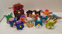 Full view of 13 McDonald's Furby collectible toys in various colors and designs with plastic bodies and fur tufts