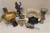 Full view of lot with brass ashtrays, figurines including Mount Rushmore, knight, bells, and decorative items