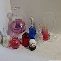 Photo showing the full assortment of Avon cologne bottles, decorative bells, and vases arranged on a white surface
