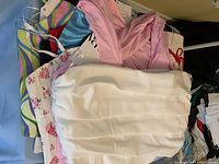 Pile of assorted new ZARA bustiers and crop tops, various colors and patterns visible, mainly white and pink tops on top.