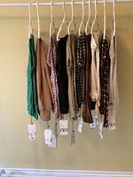 10 pairs of women's pants hanging on hangers showing variety of patterns and solid colors with Zara tags