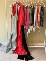 Rack view of three jumpsuits and eight pants, size 1X.