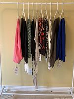 10 pair of women's pants on hangers, assorted colors and patterns, new with tags