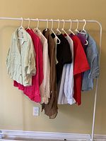 Overview of 10 Zara women's tops hanging on white metal rack in various colors and styles, size XL