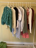 Full view of clothing rack with the 10 Zara clothing pieces hanging, showing a range of colors and styles including tops and dresses.