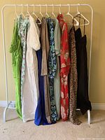 Overall view of nine visible dresses on rack showing various colors and patterns