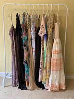 Full rack view showing all dresses on white garment rack