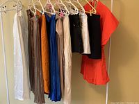 Photo showing all hanging skirts, shorts, and romper in various colors and fabrics on a white clothing rack.