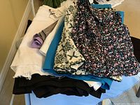 Top view of 10 folded shorts of varying styles and colors showing floral, geometric patterns and solids.