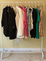 Photo showing all 10 Zara tops on a clothing rack, assorted colors including black, beige, pink, green, floral prints, and light browns.