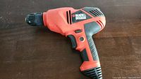 Side view of orange and black Black & Decker electric drill showing brand name and design details