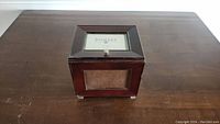 Wooden picture box on wooden surface showing top and front glass photo frame windows
