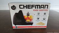 Photo showing Chefman Food Chopper box with product image, brand, 1.5 cup capacity, safety lock, and dishwasher-safe features clearly visible.