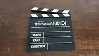 Photo of Disney's Hollywood Studios black film slate clapperboard sign, lying flat showing front side with blank Scene, Take, and Director sections