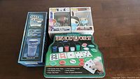Full lot including the Take A Drink drinking game, Texas Hold'em Poker Set, and two boxed Funko Pop figures (MTV Moon Person and Sub-Zero) on a wooden table.