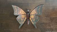 Full view of metal butterfly wall hanging showing wing colors and body detail