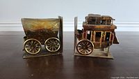 Side view of both Western-themed metal bookends shaped like parts of a stagecoach, showing intricate wheel details.