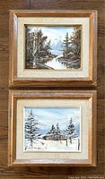Pair of framed vintage oil paintings by M.S. Hansen, showing fall and winter landscapes.