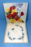 Closed original box with floral painted lid showing red and yellow flowers and blue vase