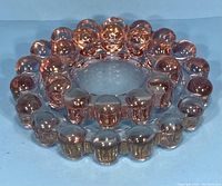 Two pink glass ashtrays stacked, showing bubble edge design and transparency