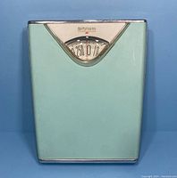 Full front view of vintage robin egg blue Borg-Erickson bathroom scale showing metal body and dial window.