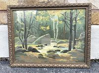 Full view of framed vintage oil painting showing forest landscape with trees, rocks, and water.