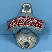 Front view showing embossed red painted 'Drink Coca-Cola' logo and mounting holes.