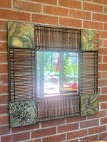 Frontal view of the square wall mounted framed mirror highlighting the wood slat frame and ornate carved corner blocks.
