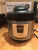 Front view of the Instant Pot with control panel and box in background showing model and branding.