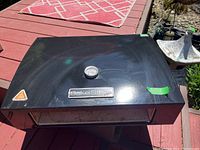 Top view of the black BakerStone pizza oven showing the surface condition and outdoor setting.