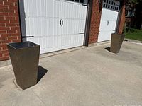 Pair of tall, tapered square Veradek planters placed outdoors near a white garage door.