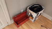Ridgid WD4079 wet/dry vacuum in original box with orange and black design and a red empty toolbox beside it.
