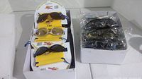 Box of 12 adult and 12 kids sport sunglasses with yellow pouches shown, some individually packaged.