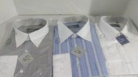 Photo showing three men's dress shirts packaged in plastic: gray, blue and white striped with white collar, and solid white.