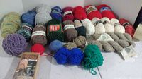 Photo showing an assortment of full and partial skeins of various wool yarns including different colors and textures.