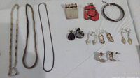 Full layout photo of all 12 pieces including necklaces, earrings, pendants and bracelet.