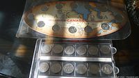 Two Millennium Canada 1999 coin sets in original packaging, showing coins arranged on a Canada map.