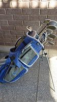 Blue and grey Nike golf bag standing open with golf clubs inside showing the full set in a side view