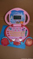 Open Disney Magic Wand kids laptop showing screen with Cinderella and keyboard with heart-shaped buttons