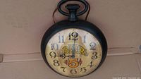 Full view of the clock showing the black frame and top loop handle, including the 'BEER 5¢' text on the clock face.