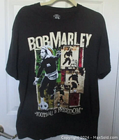 Black Bob Marley 'Football Is Freedom' t-shirt, size large, featuring multiple images of Bob Marley playing football with colored blocks and text graphics on front.