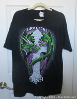 Full front view of black t-shirt hanging on a hanger, showing the dragon and cross graphic with text.