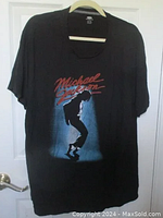 Full view of black Michael Jackson t-shirt featuring silhouette graphic and red script text.
