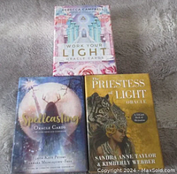 Three oracle card decks in their boxes: Work Your Light, Spellcasting Oracle, Priestess of Light Oracle.