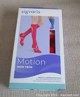 Front packaging of Sigvaris Motion High Tech knee high compression socks in red showing branding and product image