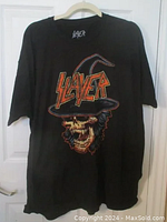 Full view of black Slayer t-shirt showing front graphic of skull with witch's hat and band name.
