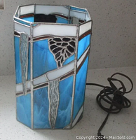 Lamp front and side view showing blue stained glass panels with white borders and clear textured icicle glass accents. Lamp power cord visible.