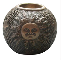 Front view showing textured ridged pattern and sun face relief on votive candle holder with matte dark gold finish.